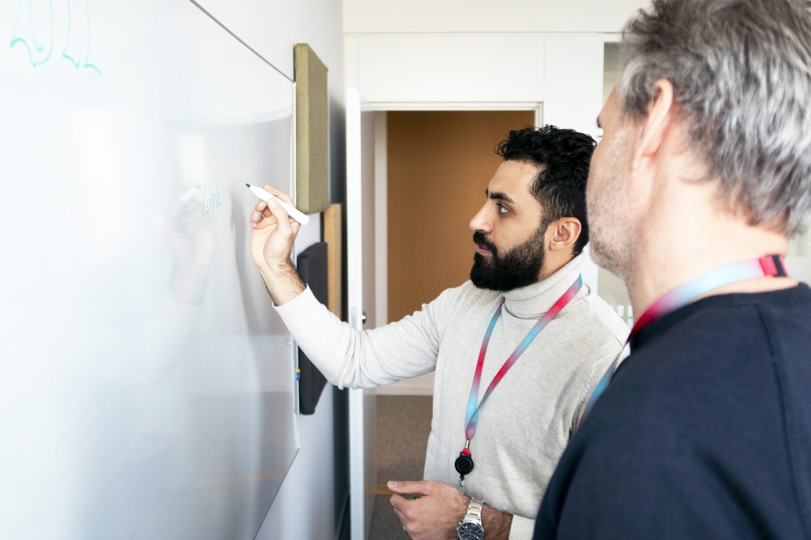 Combine employees working together on a whiteboard